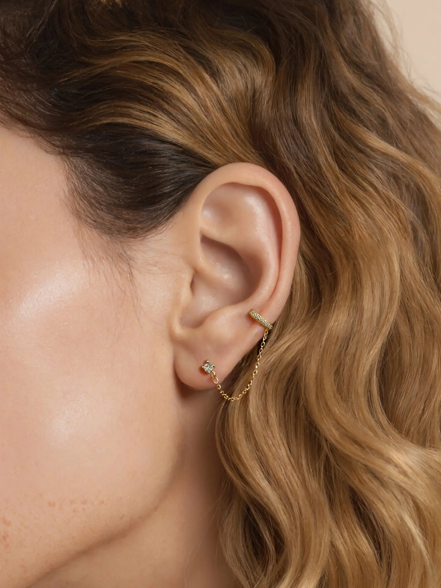 This innovative ear thread combines a sparkling cz stud for your lobe with a graceful chain that leads to a secure clip for your upper ear